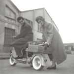 1950 lady placing suitcase on Lambretta scooter with man on it