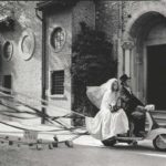 1960 married couple on Lambretta scooter in front of building