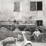1960 Lambretta scooter with two ladies in front of water wheel