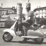 1960 man on Lambretta scooter on square