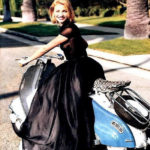 Cameron Diaz in black dress on blue and white Lambretta scooter